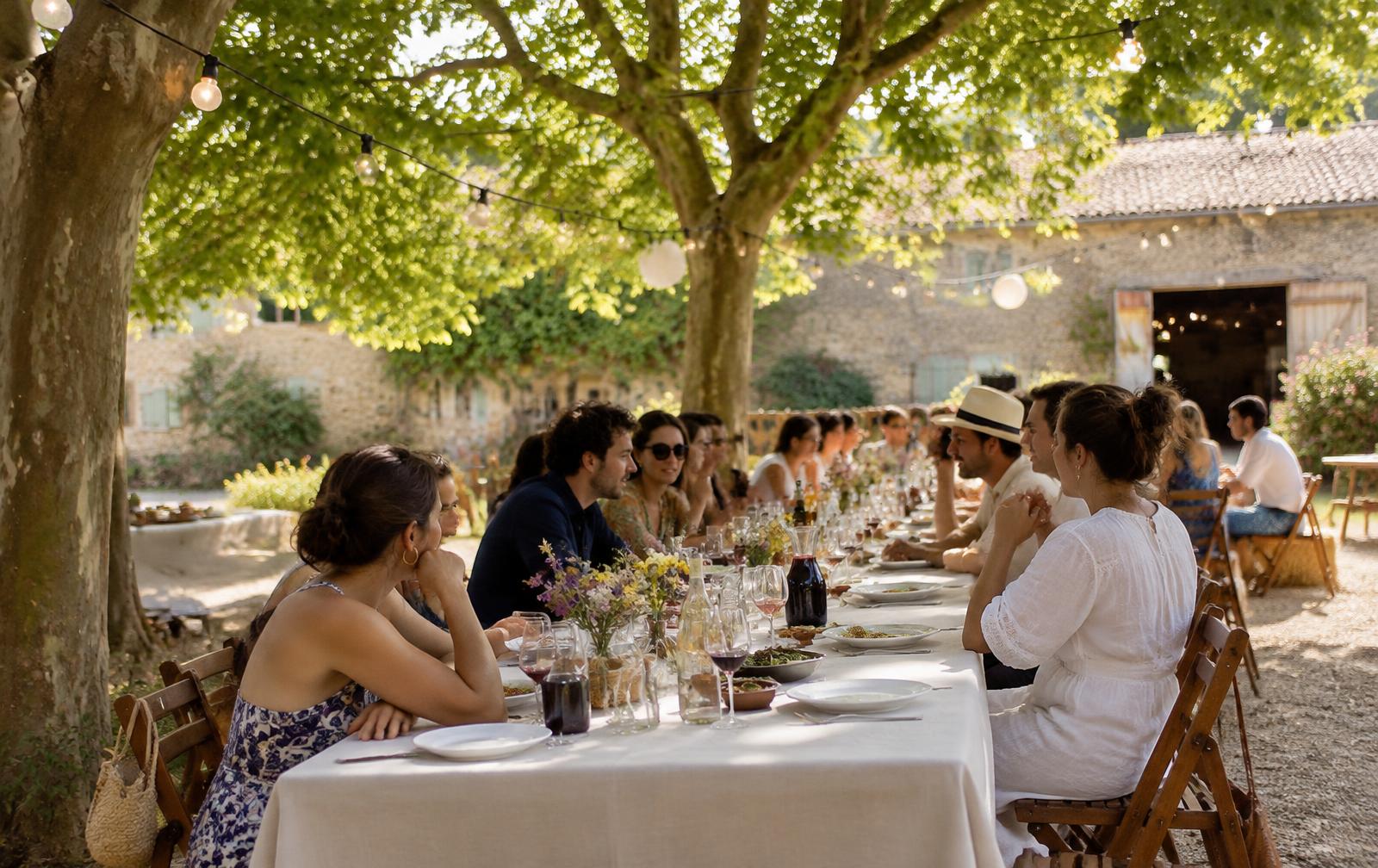 Grande tablée dehors sous les arbres, un midi d'été